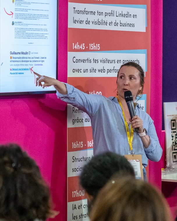 Amélie Starace en conférence, micro à la main, présentant sa stratégie LinkedIn devant un public.
